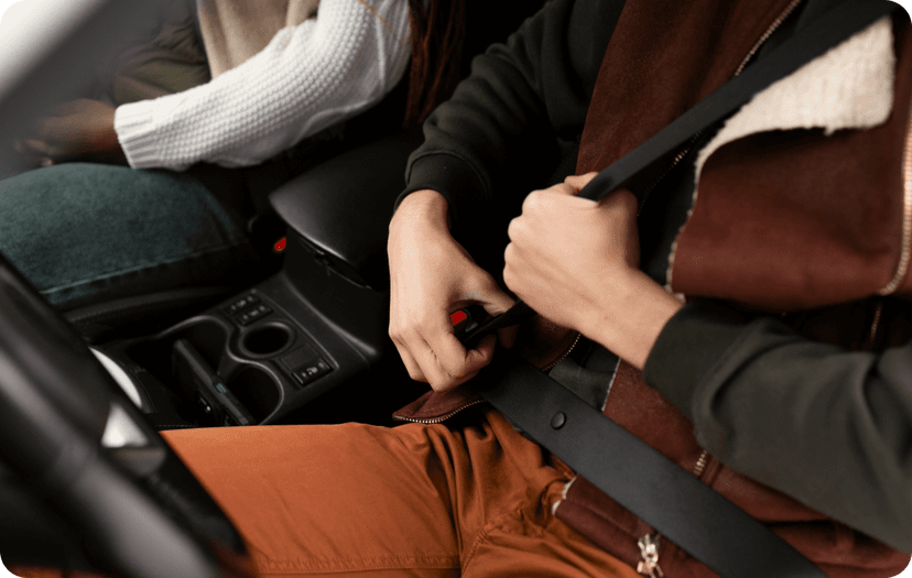 A guy adjusting his seat belt inside the car
