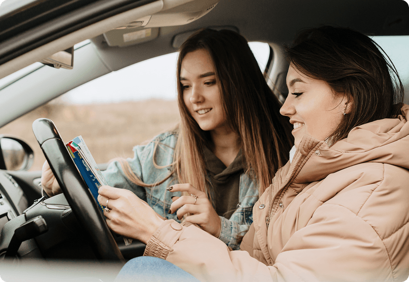 Two friends in a car, looking for directions.