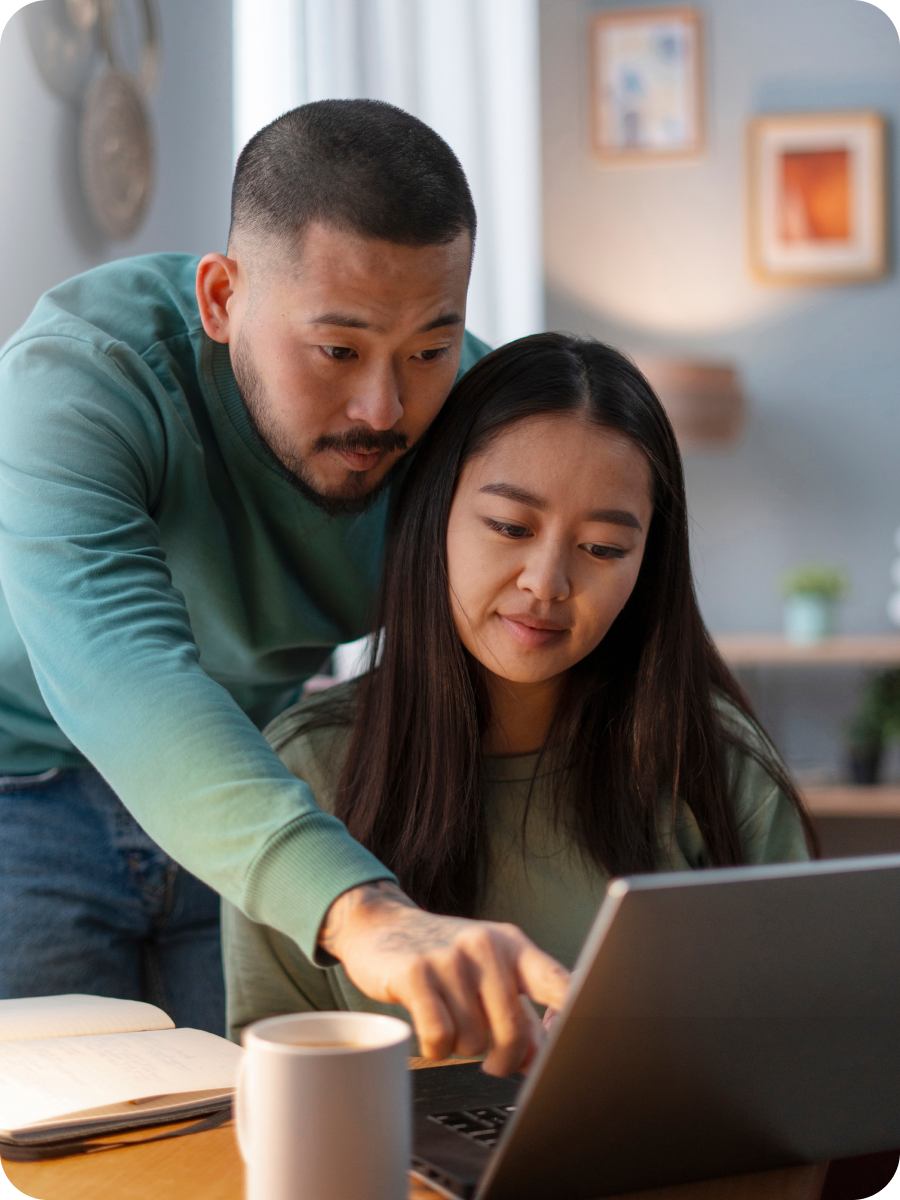A man showing a wife something on her laptop