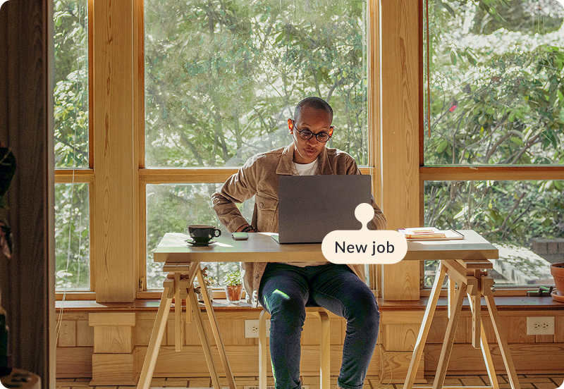 Person working at their desk, at home on a laptop. The tag reads "New job".