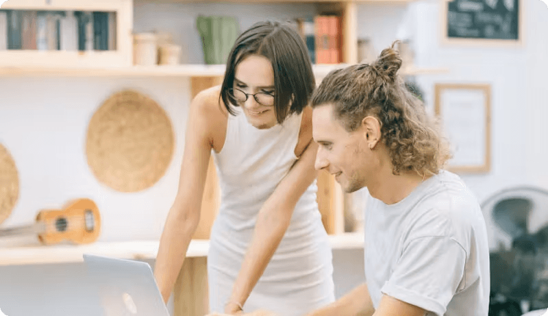 Colleagues checking insurance plans on laptop