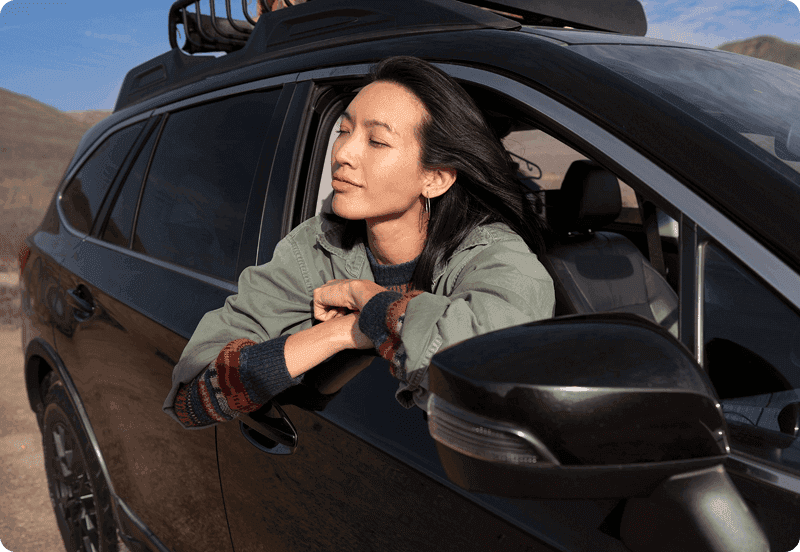 Person breathing out of their car window.