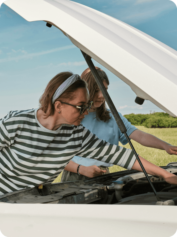 A woman attending a broken car.