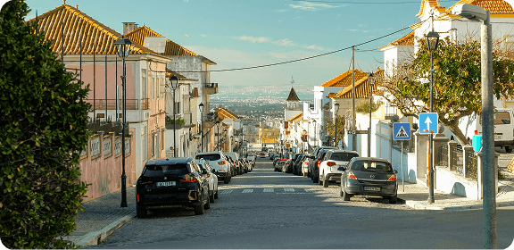 A street in Lisbon, Portugal with cars parked on the side.