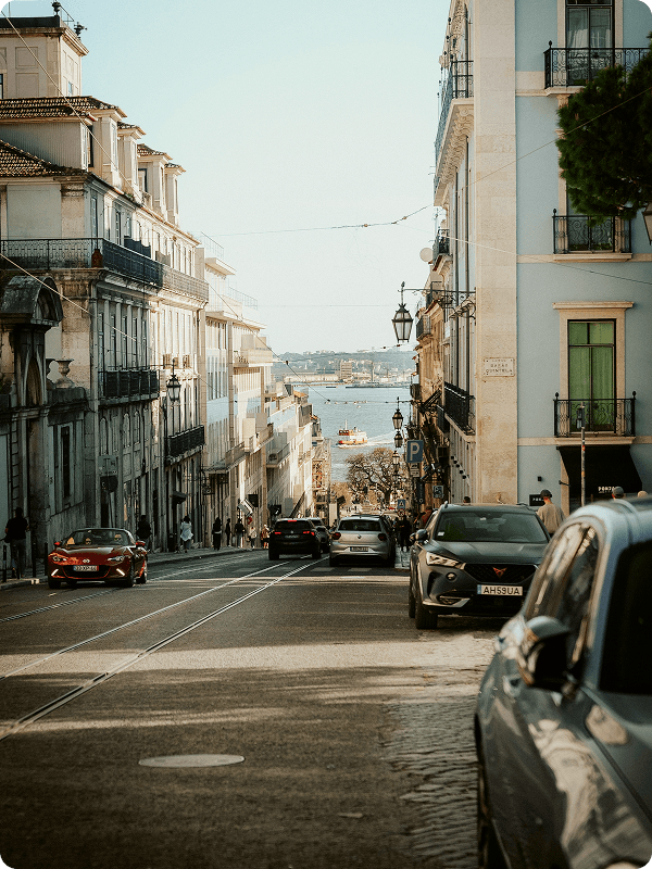 A street in Lisbon, Portugal with cars parked on the side.