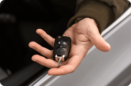 A person holding a car key.