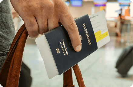 Persona sosteniendo un pasaporte en la mano en el aeropuerto.