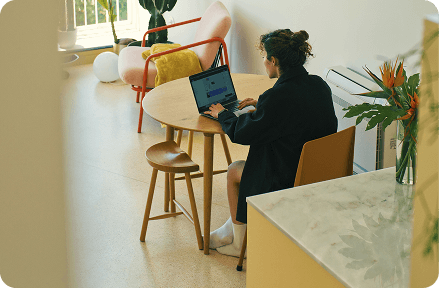 A person sitting at a cafe, working on a laptop.