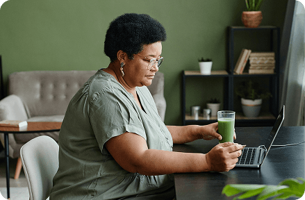 A middle-aged woman looking at her laptop.