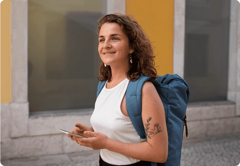 Woman walking through streets in Spain checking her golden visa application status on her phone