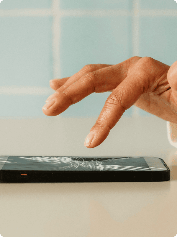 Person's hand trying to click on a damages phone screen.
