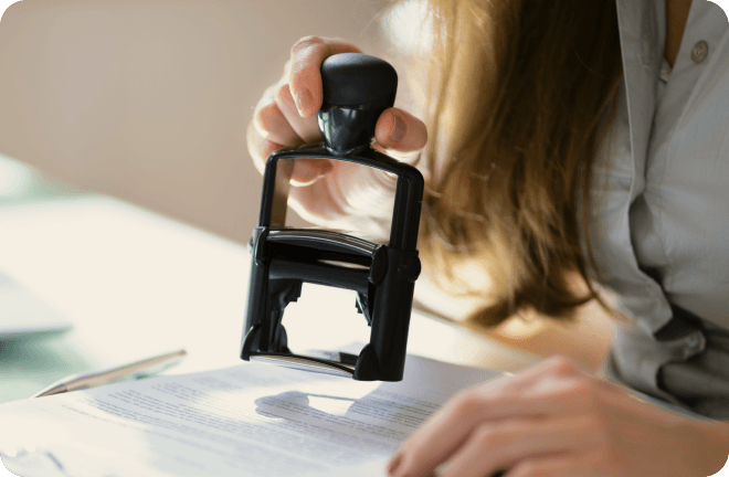 A visa stamp being put on a document.